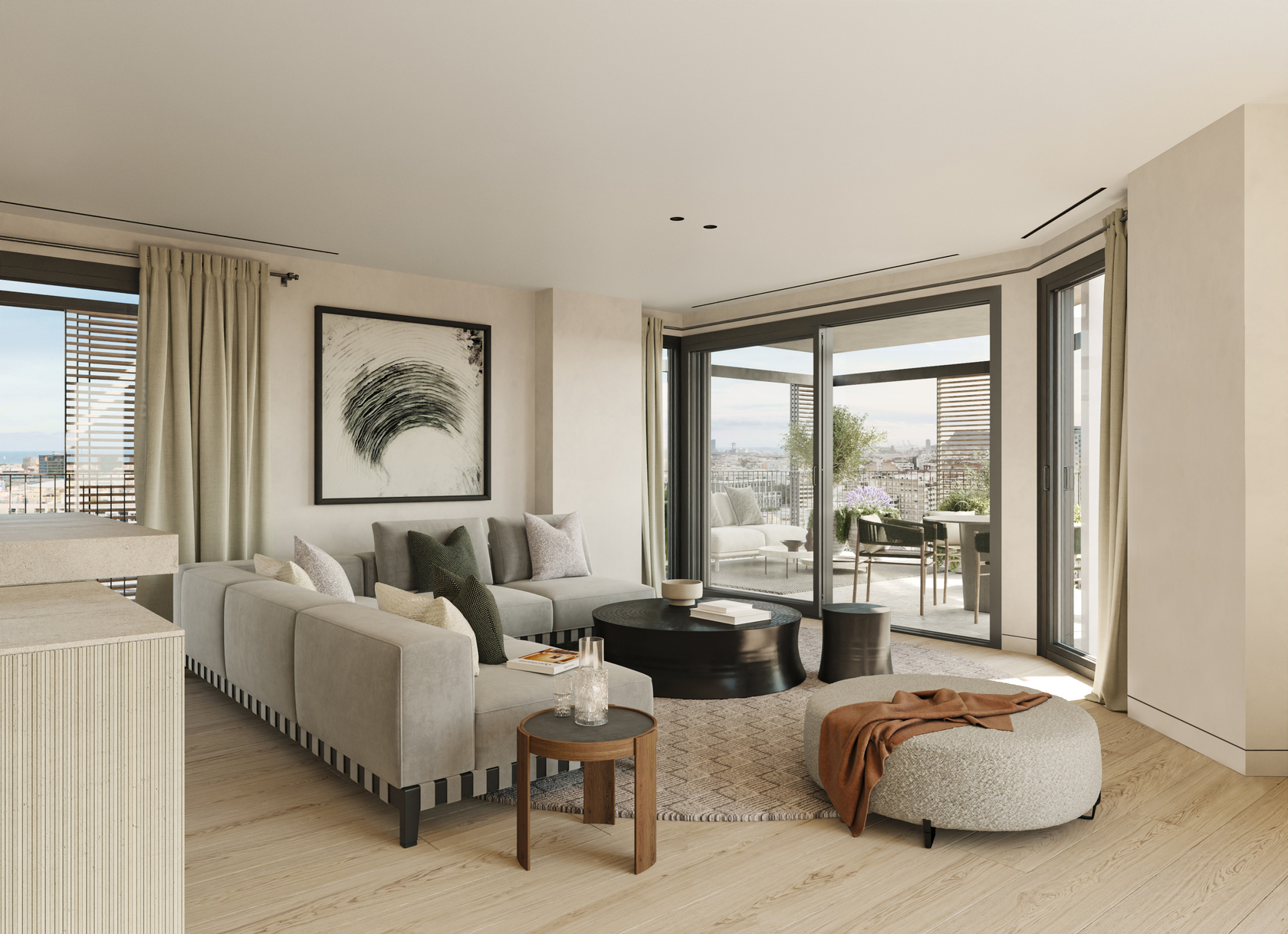 Open-plan living room with a stone kitchen island, a light grey sofa and a round stone coffee table, with the Torre Glòries visible through the terrace doors.